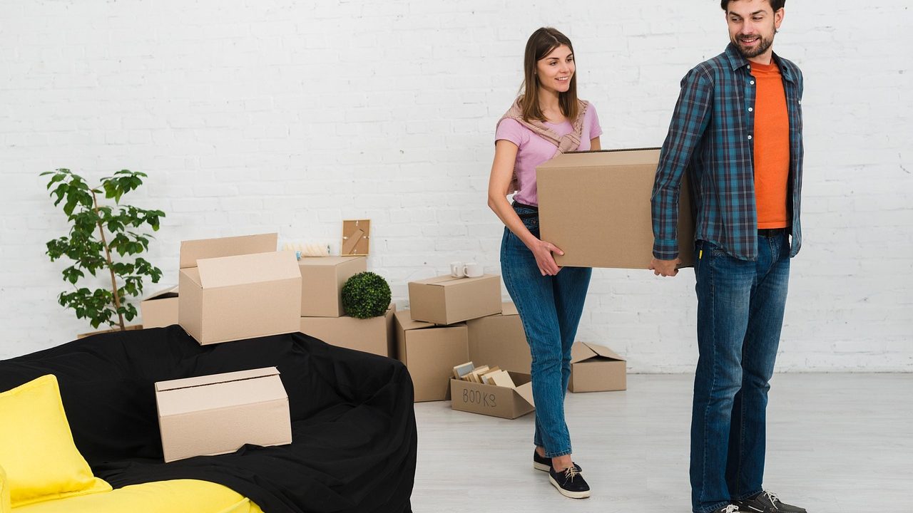 Paar mit Umzugskartons in einer leeren Wohnung